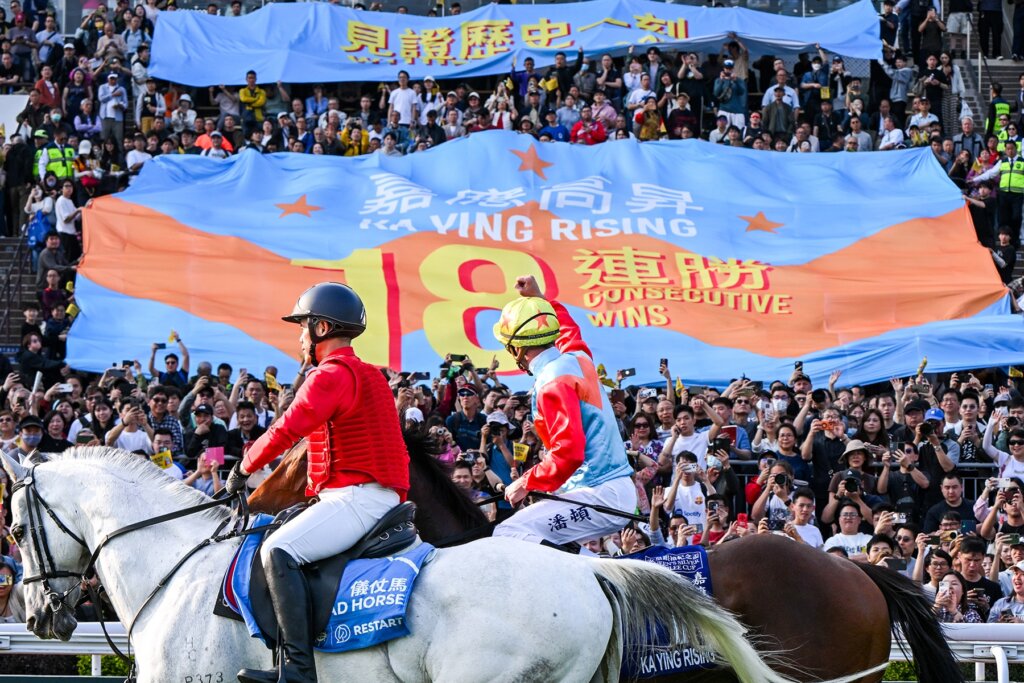 Zac Purton and Ka Ying Rising lap up the adoration of fans at Sha Tin in front of a banner acknowledging the record-breaking 18 straight wins
