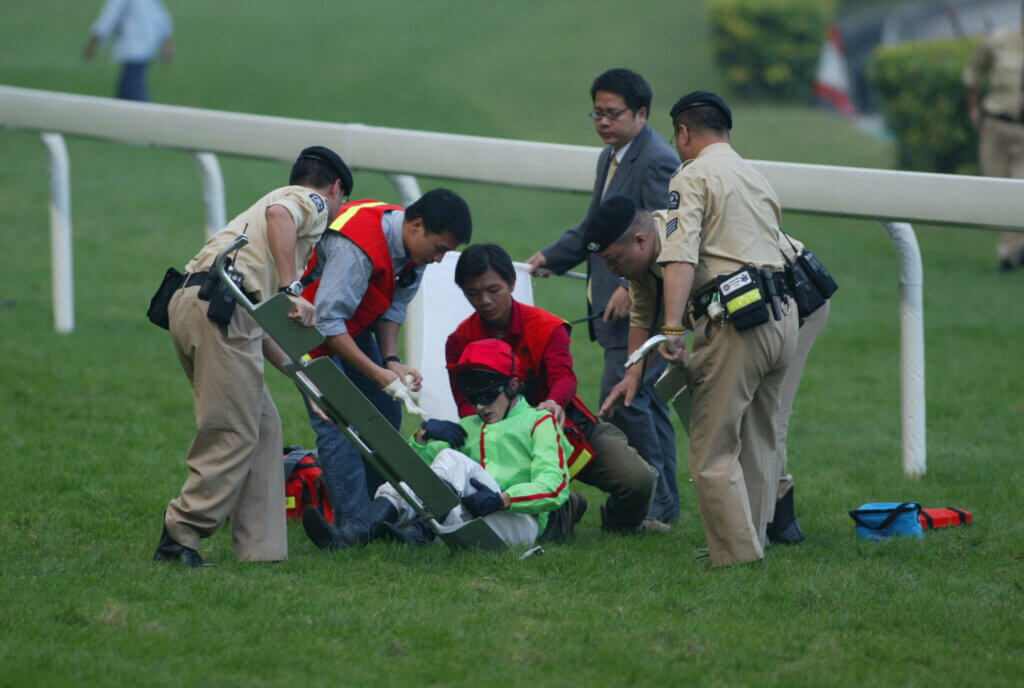 Shane Dye being attended to by medical staff after a race fall at Happy Valley in 20023