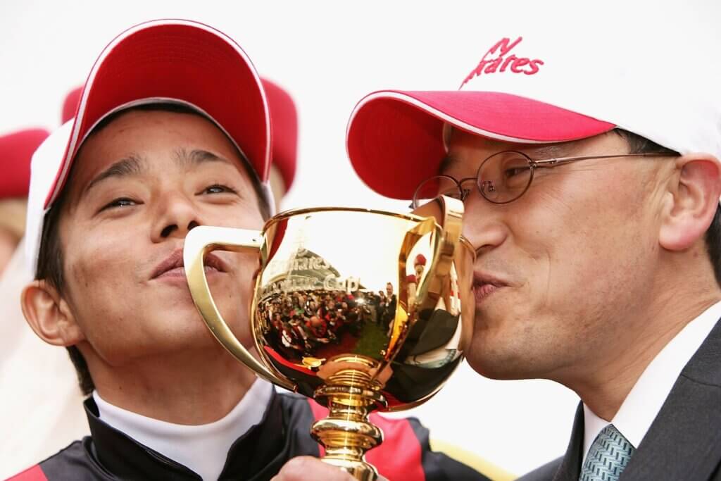 Katsuhiko Sumii and Yasunari Iwata kiss the Melbourne Cup in 2006