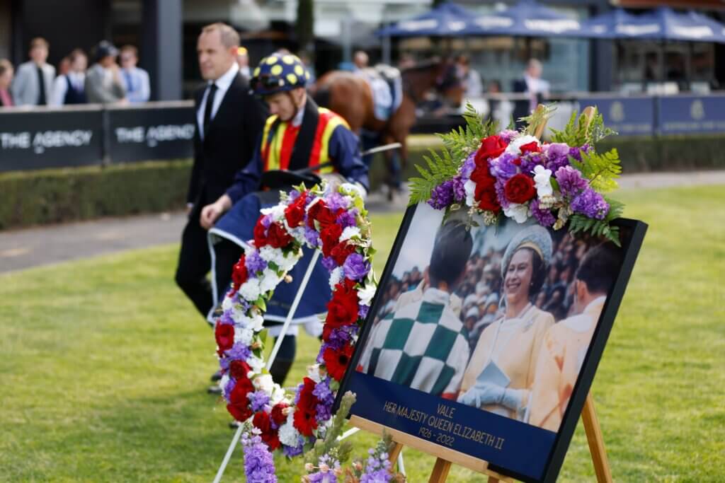 Chris Waller and James McDonald walk by a floral tribute to The Queen at Rosehill in 2022