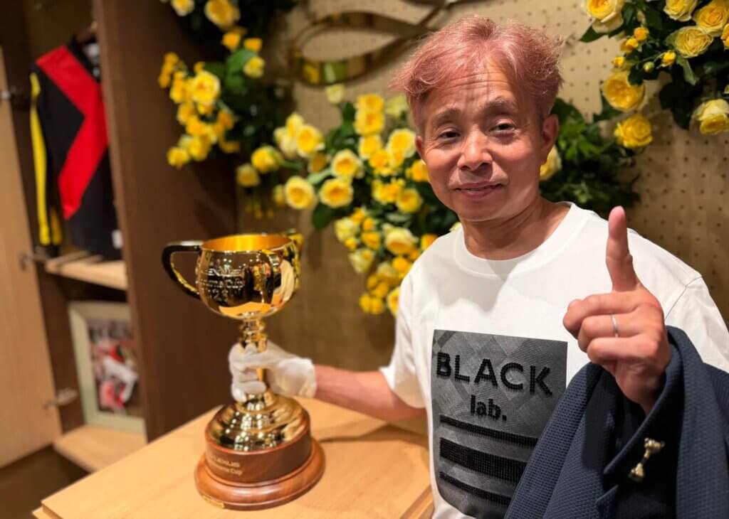 Yasunari Iwata posing with the Melbourne Cup